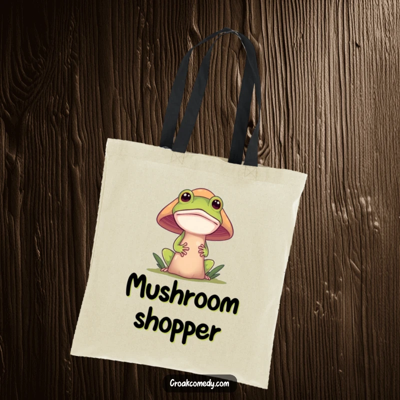 Funny frog tote bag, a curious frog peeking from behind a mushroom, ideal for carrying essentials with a touch of woodland whimsy.
